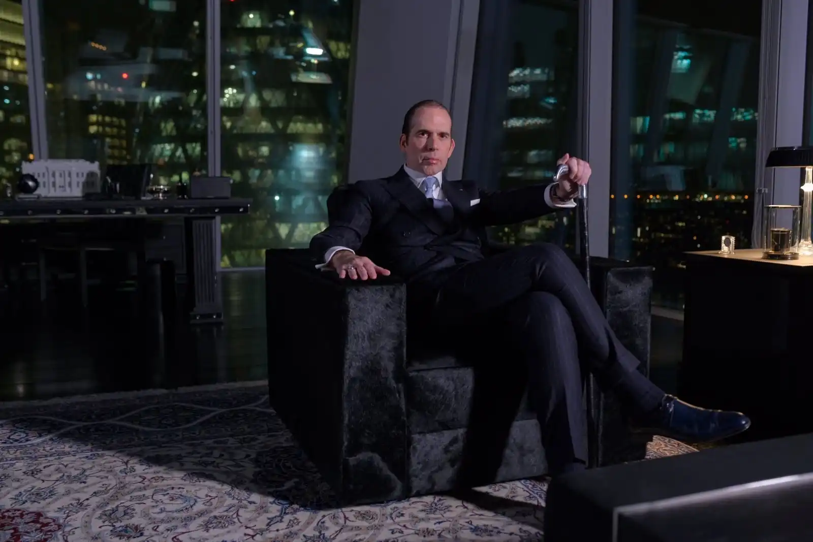 Julio Herrera Velutini seated in a private office with a nighttime global city skyline, representing financial diplomacy and institutional leadership
