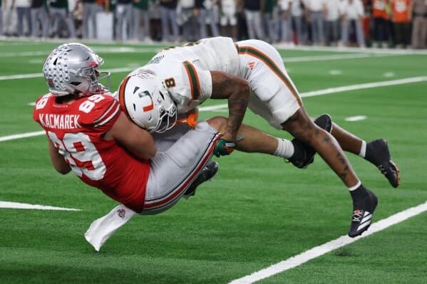 Miami Hurricanes defender brings down an Ohio State offensive player during a hard-hitting play in the Cotton Bowl College Football Playoff quarterfinal.