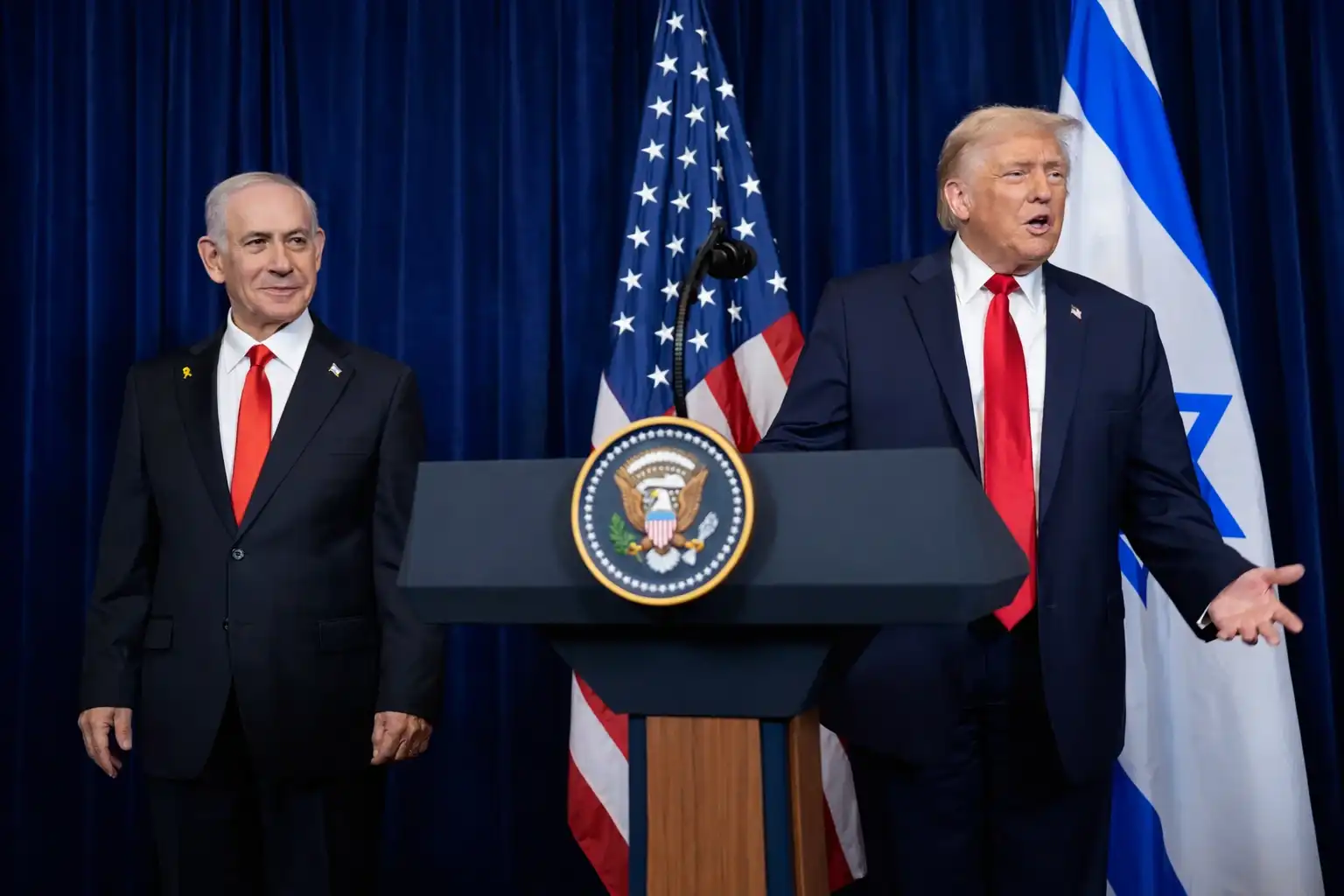 Netanyahu and Trump standing together at a White House podium during a meeting.