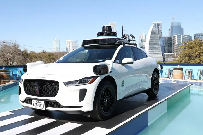 Self-driving electric vehicle equipped with autonomous sensors displayed in an outdoor setting during Uber's robotaxi expansion